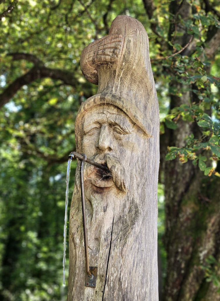 Max Ostenrieder Toni Preis Holztrog-Brunnen mit Januskopf