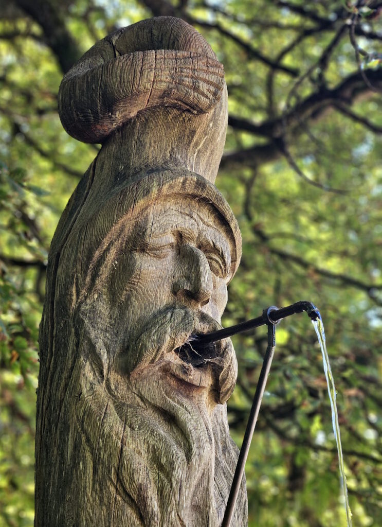 Max Ostenrieder Toni Preis Holztrog-Brunnen mit Januskopf