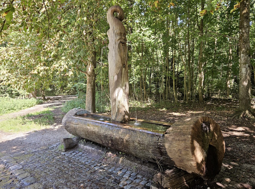 Max Ostenrieder Toni Preis Holztrog-Brunnen mit Januskopf