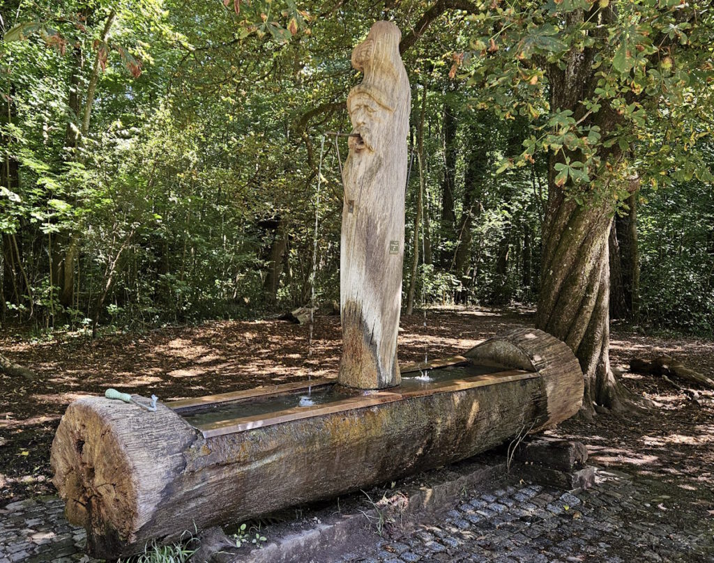 Max Ostenrieder Toni Preis Holztrog-Brunnen mit Januskopf